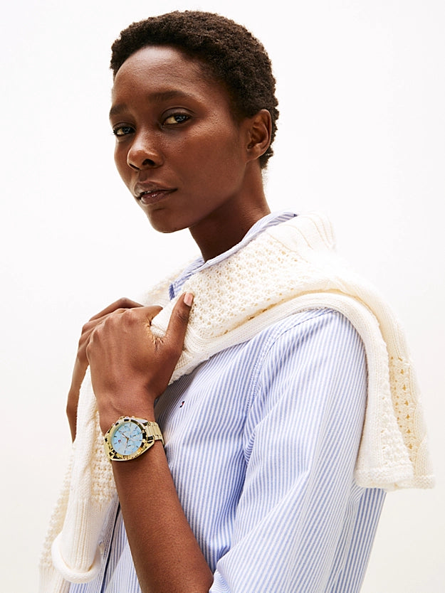 Reloj Tommy Hilfiger dorado en la muñeca de mujer