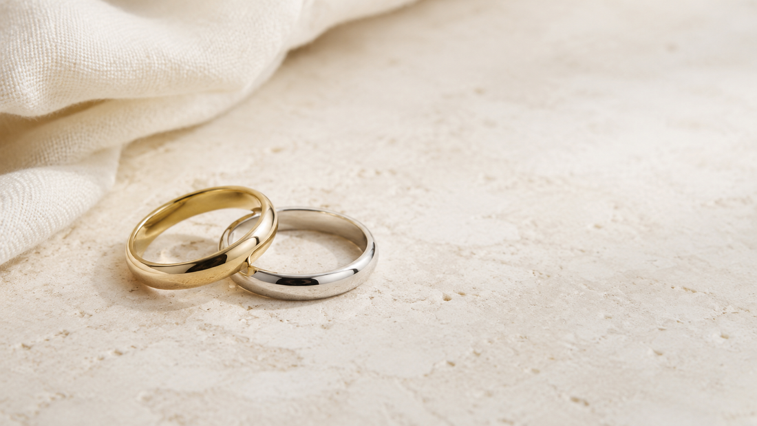 Dos alianzas de boda en oro amarillo y oro blanco sobre piedra clara